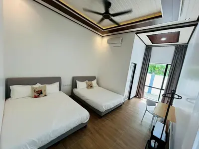 a bedroom with two beds and a ceiling fan at Khoo Family Villa in Ipoh