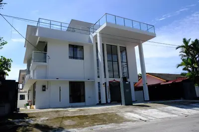 a white house with a balcony on top of it at Khoo Family Villa in Ipoh