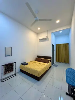 a bedroom with a bed and a ceiling fan at Haneya Homestay in Kampong Banggol Pasir