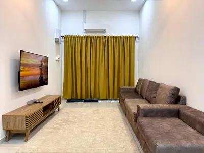 a living room with a couch and a green curtain at Haneya Homestay in Kampong Banggol Pasir