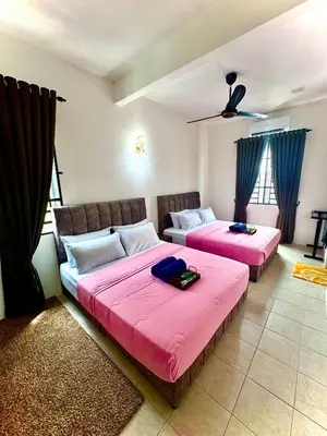 two beds in a room with pink sheets at Lapang Tuju Private Pool Homestay in Sungai Petani