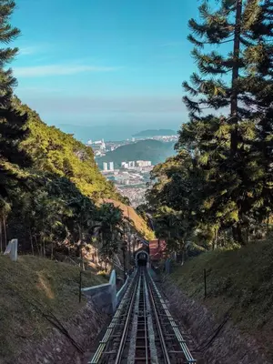 a train traveling down the tracks on a hill at sea city cozy familystay 3br 10 pax in George Town