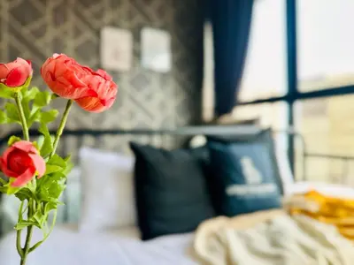 a vase of red roses sitting on a bed at sea city cozy familystay 3br 10 pax in George Town