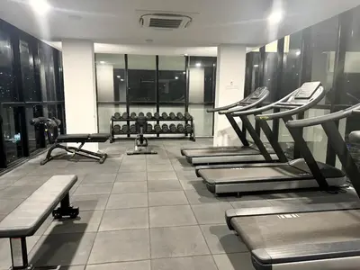 a gym with several treadmills and machines at sea city cozy familystay 3br 10 pax in George Town