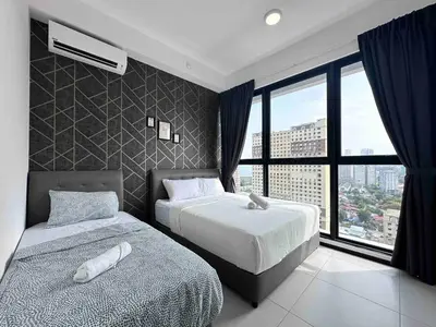 a bedroom with two beds and a large window at Urban suites 3BR 10pax in George Town