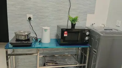 a blue table with a microwave and a refrigerator at Peaceful Abode Familystay 3 br 10 pax in George Town