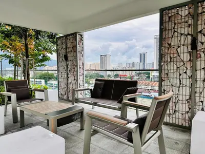 a balcony with chairs and a couch and a table at Peaceful Abode Familystay 3 br 10 pax in George Town