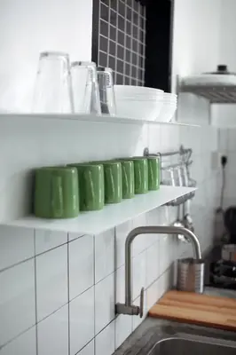 a row of green dishes on a shelf in a kitchen at Stay SongSong Mount Erskine in George Town
