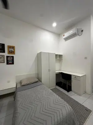 a bed in a room with a desk and a bed sidx sidx sidx at comfy soho in Seri Iskandar