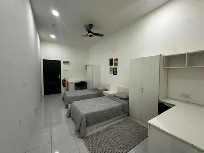 a bedroom with two beds in a room with a kitchen at comfy soho in Seri Iskandar
