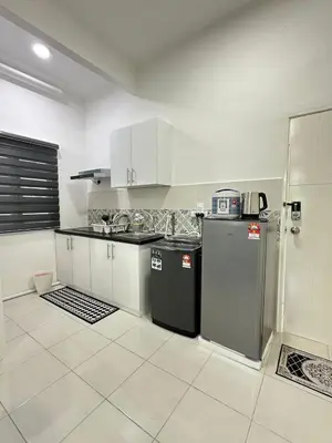 a kitchen with white cabinets and a black refrigerator at zamanss homestay in Kampong Simee