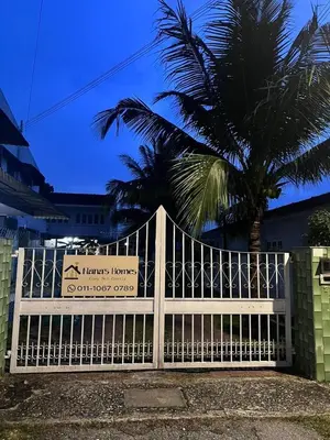 a white fence with a palm tree behind it at 728 NanasHomes Little Bungalow in Ipoh 10 pax in Ipoh