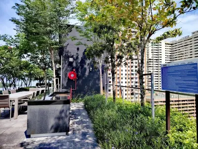 a park with benches and tables and trees and buildings at The society Apartment George town 3br 10 pax in George Town