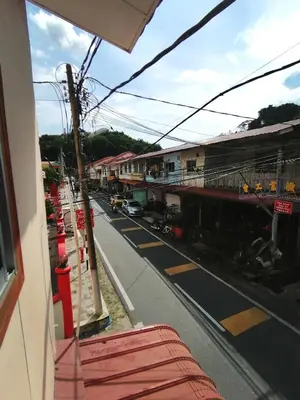 a view of a city street from a bus at \u90a6\u54af\u5c9b\u6f2b\u753b\u6c11\u5bbf in Pangkor