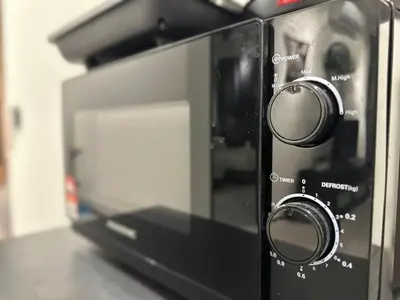 a microwave oven with twoobs on top of a counter at cozy family stay suites apartment 3br 10 pax in George Town
