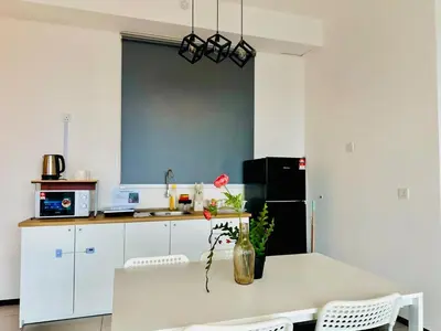 a kitchen with a table with a vase with a flower on it at cozy family stay suites apartment 3br 10 pax in George Town
