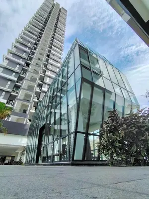 a glass building with a tall building in the background at 15 min airport to apartment 3br 10pax in George Town