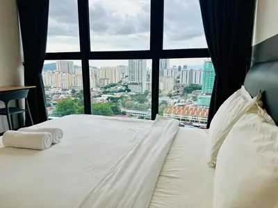 a bed with two pillows and a large window at Near komtar apartment in goergetown 3br 10 pax in George Town