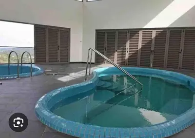a swimming pool in a building with a blue tub at Belladira Homestay CH in Brinchang
