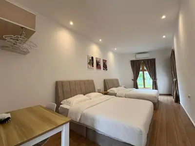 a hotel room with two beds and a table at Hillview Ipoh in Ipoh