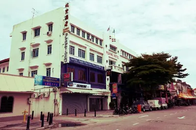 a tall white building on the side of a street at Peking Hotel in George Town