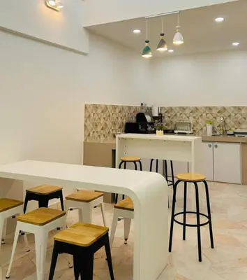 a kitchen with a white counter and stools at Ipoh Garden 5 Homestay in Ipoh