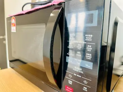 a microwave oven with its door open on a table at luxury familystay 3br 10 pax in Jelutong