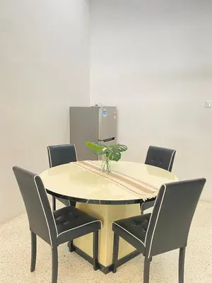 a table with four chairs and a plant on it at 8 pax KakaHomestay Tmn Petani Jaya in Sungai Petani