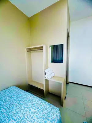 a room with a bed and a shelf with towels at Cozy with Sea & City Views 3BR 12PAX in Jelutong