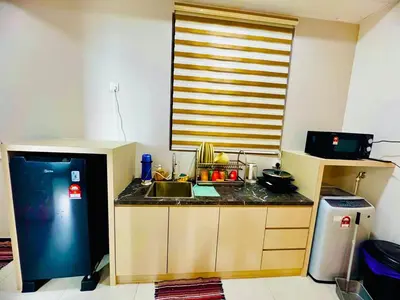 a small kitchen with a sink and a refrigerator at Cozy with Sea & City Views 3BR 12PAX in Jelutong
