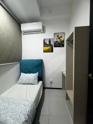 a bedroom with a bed and a blue headboard at Luxury Suites with Sea & City Views 3BR 12PAX in Jelutong