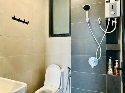 a bathroom with a shower with a toilet and a sink at Luxury Suites with Sea & City Views 3BR 12PAX in Jelutong