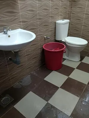 a bathroom with a sink and a toilet and a bucket at Krishna Villa in Simpang