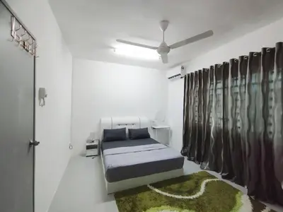 a bedroom with a bed and a ceiling fan at Lilly Grove Homestay in Kampong Ayer Melintas Besar