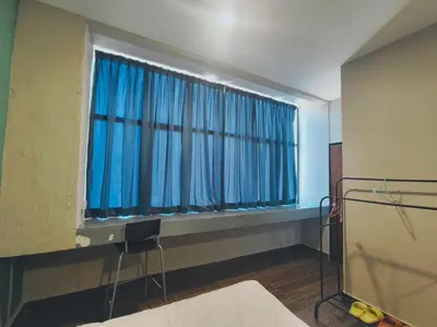 a hospital room with a window with blue curtains at Wayton Cottage in George Town