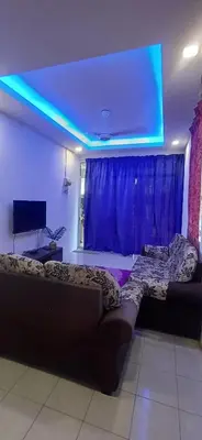 a living room with a couch and a tv at River Truss Homestay in Nibung Tebal
