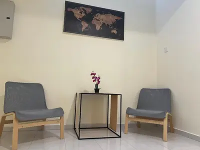 two chairs and a table with a vase of flowers at Omari 2 Marina Island Homestay Lumut in Lumut
