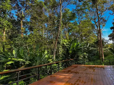 a wooden bridge with trees in the background at The HIJAU Camp & Cabin in Gopeng