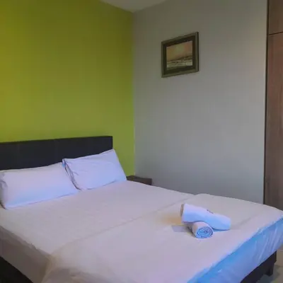 a bed with two towels sitting on top of it at Reintree Lodge Hotel Ipoh in Ipoh