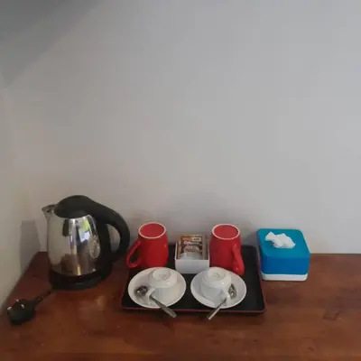 a counter with a coffee pot and cups on it at Reintree Lodge Hotel Ipoh in Ipoh