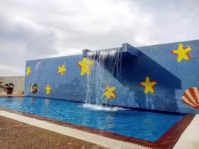 a swimming pool with a waterfall and stars painted on it at Sekinchan Kent's House with wide paddy view in Sekincan