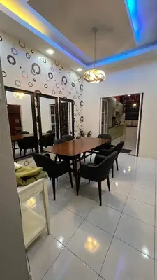 a dining room with a wooden table and chairs at Md Homestay in Kampong Kubang Menderong