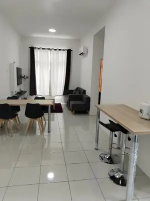 a living room with a table and chairs and a couch at Al Qarni Homestay in Ipoh