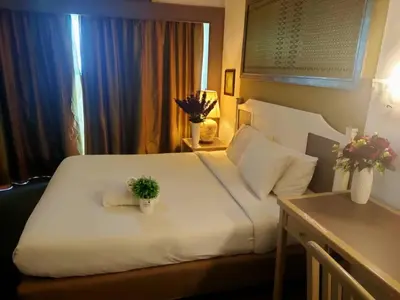 a bedroom with a white bed with a plant on it at Seaview appointment 3 bedroom in Tanjung Bungah