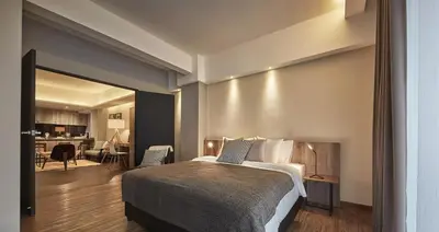 a bedroom with a bed and a living room at Tropics Eight Suites in George Town