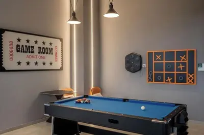 a room with a pool table and a clock at Cozy 2BR Sky Pool & Panoramic Views 1-6 Guests in Bayan Lepas