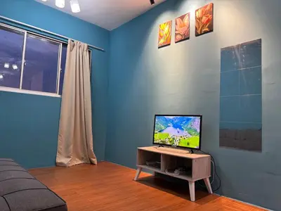 a living room with a television on a table at 2pax 1car only Malaysian guest only bayan lepas in Bayan Lepas
