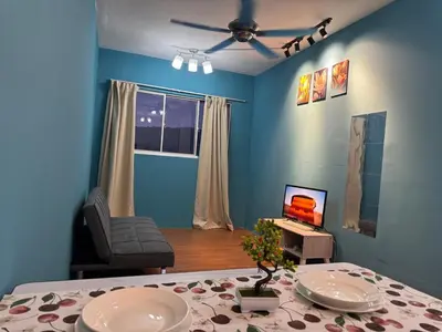 a blue living room with a table and a television at 2pax 1car only Malaysian guest only bayan lepas in Bayan Lepas