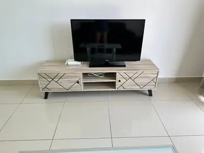 a tv sitting on top of a wooden entertainment center at HappySty in Bayan Lepas