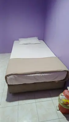 a bed in a bedroom with a purple wall at HOTEL MEDAN KiDD in Ipoh